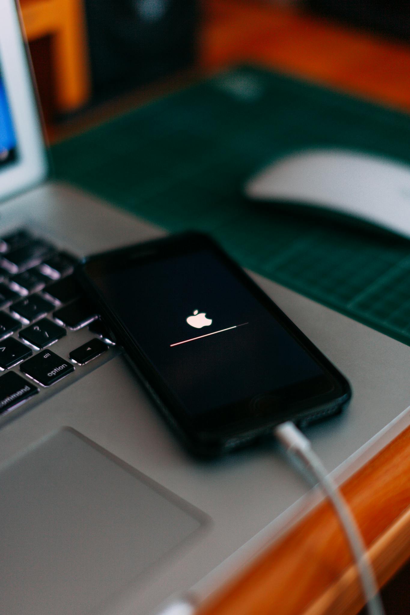 Close-up of a smartphone charging on a laptop. Ideal for tech themes.